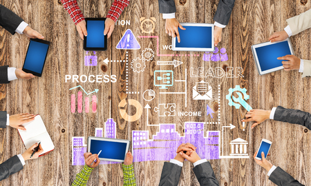 Group of people with devices in hands working together as symbol of networking and communicationの写真素材