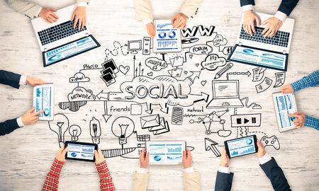 Group of people with devices in hands working together as symbol of networking and communicationの写真素材