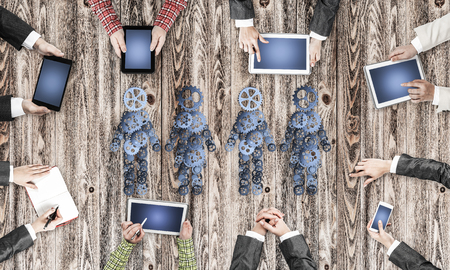 Group of people with devices in hands working together as symbol of networking and communicationの写真素材
