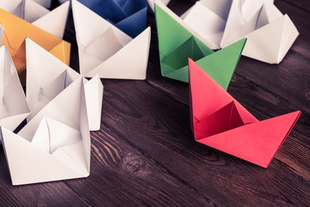 Set of origami boats on wooden table