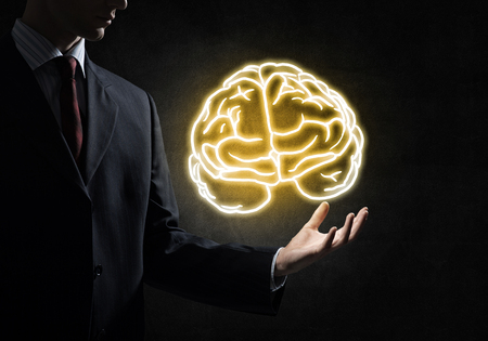 Close up of businessman hand holding brain in palmの写真素材