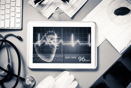 White tablet pc and doctor tools on gray surfaceの写真素材