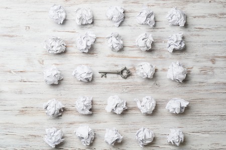 Vintage key among many balls of crumpled paperの写真素材