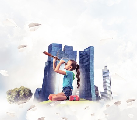 Cute kid girl on city floating island looking in spyglassの写真素材