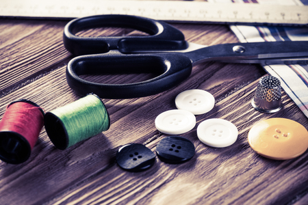 Bright image of sewing kit accessories on wooden tableの写真素材