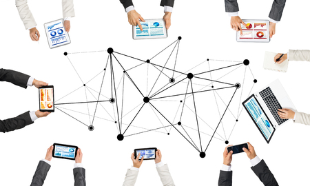 Group of people with devices in hands working together as symbol of networking and communicationの写真素材