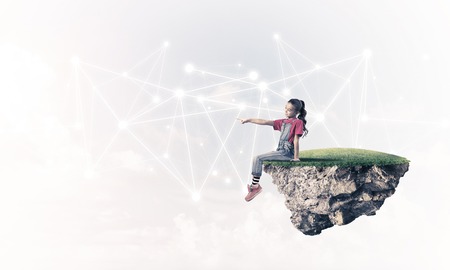 Cute girl sitting on floating island presenting social connection conceptの写真素材