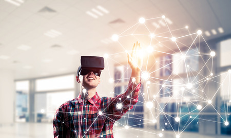 Young man with virtual reality headset or 3d glasses over connection background. Mixed media