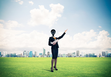 Elegant businesswoman outdoors with papers in hands and camera instead of headの写真素材