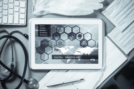 White tablet pc and doctor tools on gray surfaceの写真素材