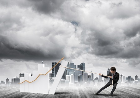 Young businessman outdoors making huge graph moveの写真素材