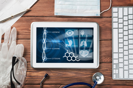 White tablet pc and doctor tools on wooden tableの写真素材