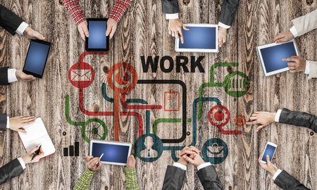 Group of people with devices in hands working together as symbol of networking and communicationの写真素材