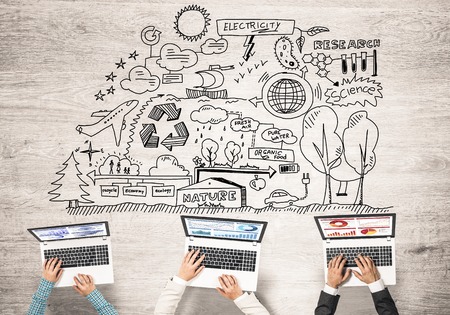 Group of three people with devices in hands working together as symbol of networking and communicationの写真素材