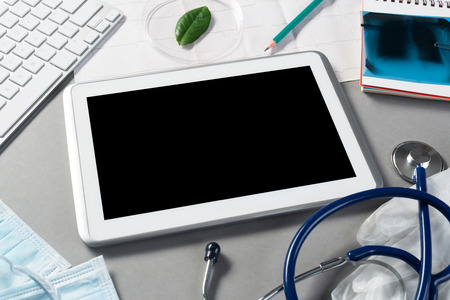 High angle shot of tablet and medical items on gray surfaceの写真素材
