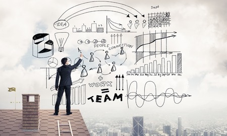 Young man with back sketching business success plan. Mixed mediaの写真素材