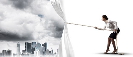 Businesswoman pulling white blank fabric. Place for textの写真素材