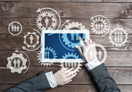 Top view of businesswoman sitting at table and using tablet deviceの写真素材