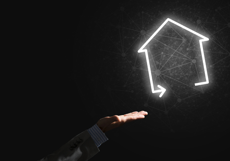 Businessman hand presenting glowing home icon or symbolの写真素材