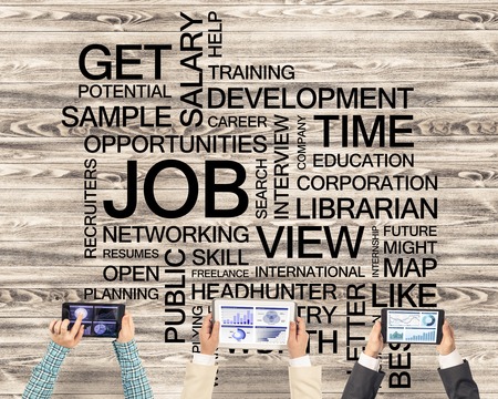 Group of three people with devices in hands working together as symbol of networking and communicationの写真素材