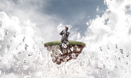 Young shocked businessman sitting on island and covering eyes with palmsの写真素材