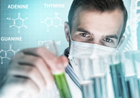 Young scientist mixing reagents in glass flask in clinical laboratory