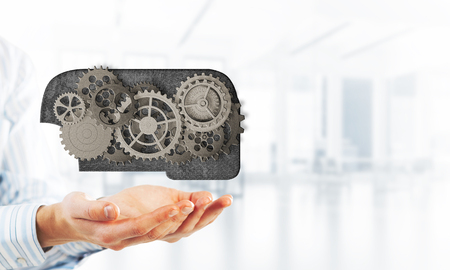 Close of businessman holding in palms gear mechanismの写真素材