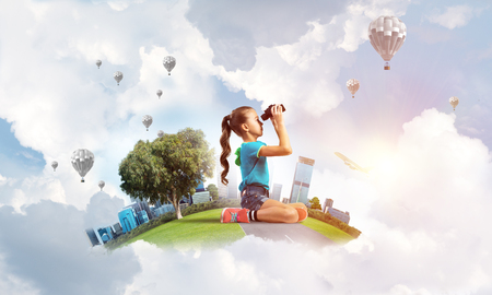 Cute kid girl on city floating island looking in binocularsの写真素材