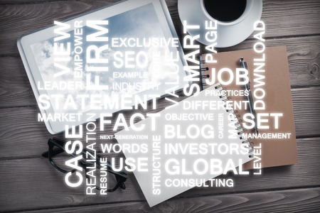 Top view of modern workplace with office stuff and business-related terms above presenting still office lifeの写真素材