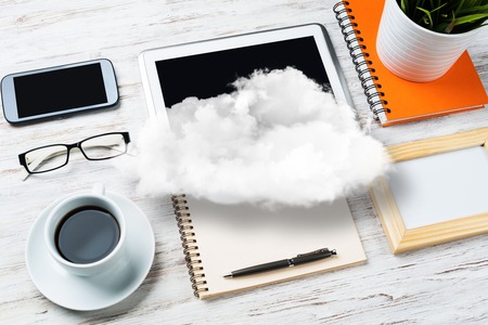Top view of modern workplace with office stuff and cloud above presenting still office life. Mixed media.の写真素材
