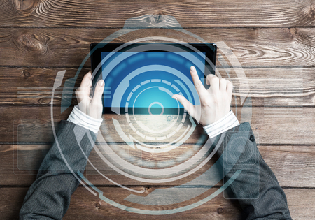 Top view of businesswoman sitting at wooden table with tablet pcの写真素材