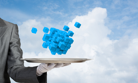 Cropped image of waiter's hand in white glove presenting multiple cubes on metal tray with cloudy skyscape on background. 3D rendering.の写真素材