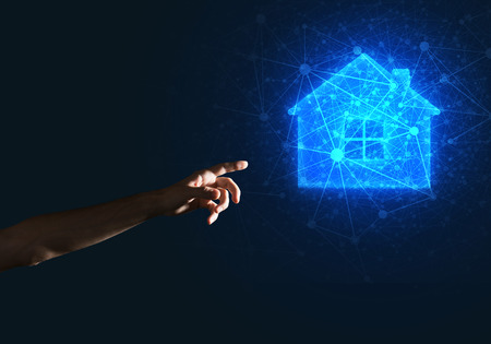 Hand of man touching with finger glowing home icon or symbolの写真素材