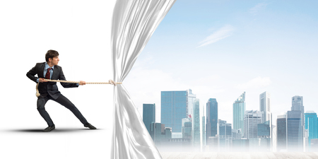 Businessman pulling white blank fabric. Place for textの写真素材