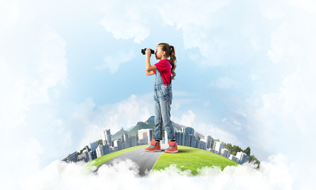 Cute kid girl on city floating island looking in binocularsの写真素材