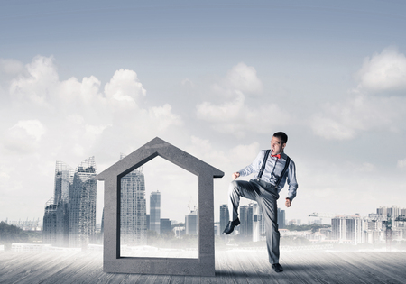 Determined businessman going to break with leg house concrete figureの写真素材