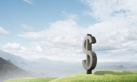 Stone dollar symbol outdoors on green hill as currency signの写真素材