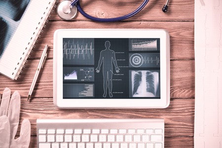 White tablet pc and doctor tools on wooden tableの写真素材