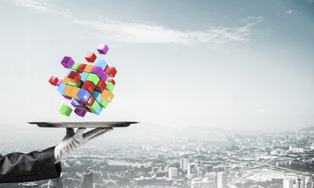 Cropped image of waiters hand in white glove presenting multiple cubes on metal tray with cityscape view on background. 3D rendering.の写真素材