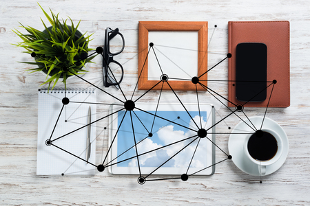 Top view of modern workplace with office stuff and social network connection above as symbol of still office life. Mixed media.の写真素材