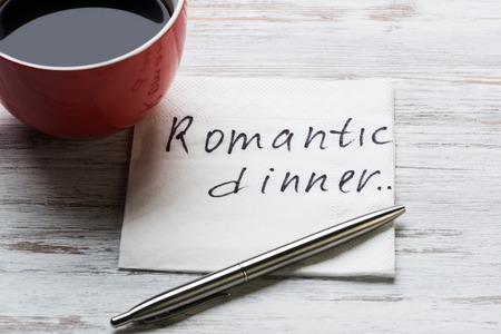 Cup of coffee and napkin with message on wooden tableの写真素材