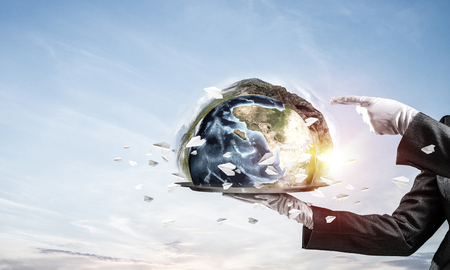 Cropped image of waitresss hand in white glove presenting Earth globe on metal tray and pointing on it with cloudy skyscape on background. 3D rendering. Elements of this image are furnished by NASA.の写真素材