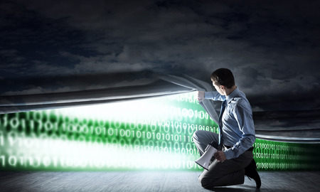 Young businessman with megaphone open curtain to technology conceptの写真素材