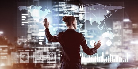 Back view of businesswoman working with virtual panel and night city at backgroundの写真素材