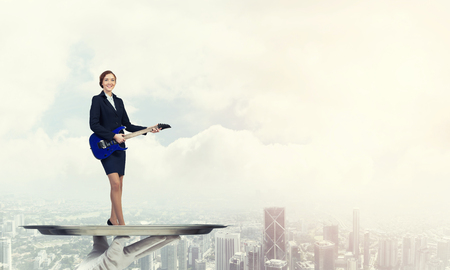 Hand of waiter presenting on tray woman playing guitarの写真素材