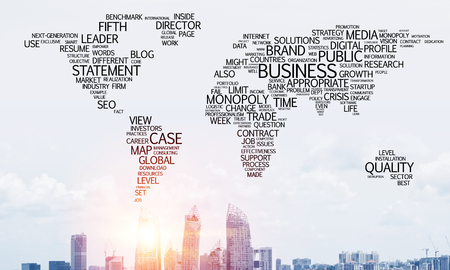 Business-related terms collage in form of world map with modern cityscape and sunlight on background.の写真素材