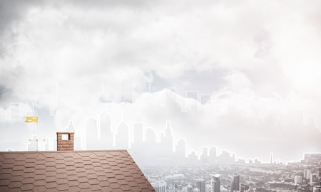 Brick house roof and modern cityscape at backgroundの写真素材