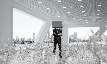 Businessman in suit with TV instead of head keeping arms crossed while standing among flying letters inside office building. 3D rendering.の写真素材