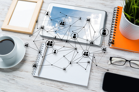 Top view of modern workplace with office stuff and social network connection above presenting still office life. Mixed media.の写真素材