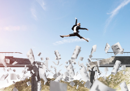 Business woman jumping over gap in bridge among flying papers as symbol of overcoming challenges. Skyscape with sunlight and nature view on background. 3D rendering.の写真素材